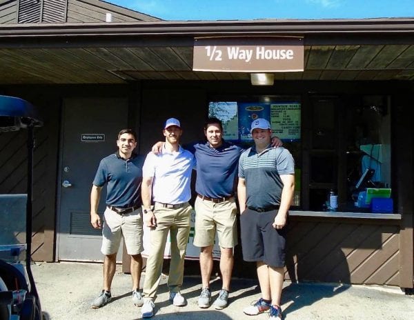 group of men in front of 1/2 Way House sign